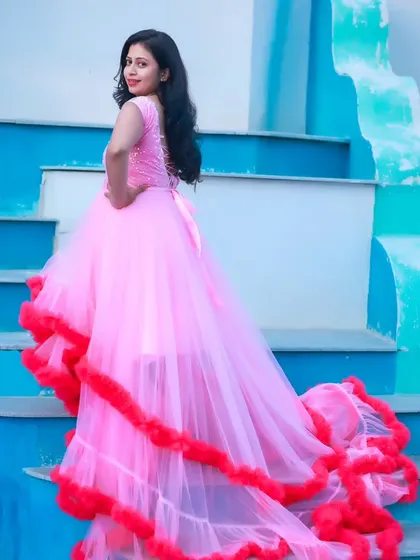 A full-length view of a beautiful pink and red ruffled gown, perfect for a glamorous maternity or pre-wedding photoshoot.