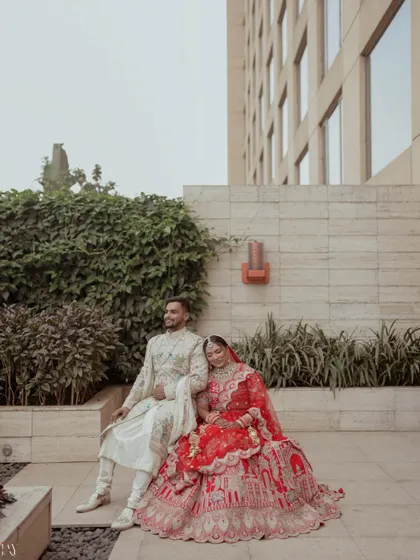 A relaxed and royal portrait of the couple seated outdoors.
