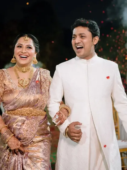 Pure happiness on the faces of the bride and groom as they walk through a shower of flower petals.