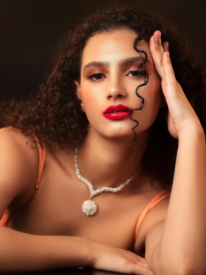 A stunning beauty portrait focusing on the model's flawless makeup and jewelry. The soft lighting and direct gaze create a classic and elegant look.