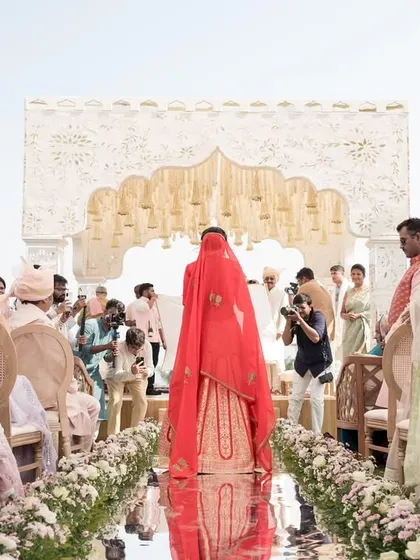 The bride's grand entrance on a reflective mirror aisle, creating a stunning visual as she walks towards the mandap.