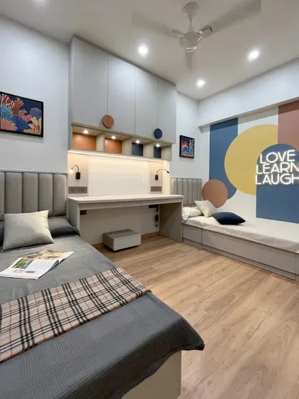 A full view of the shared kids' bedroom, showcasing the two beds and the central study area with ample overhead storage. The design is perfect for fostering sibling bonding and creativity.