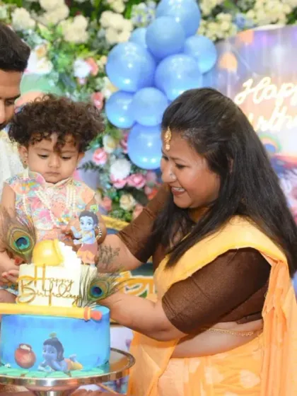 The cake cutting ceremony for Viraaj's first birthday. The Krishna-themed cake is a wonderful centerpiece for the celebration.