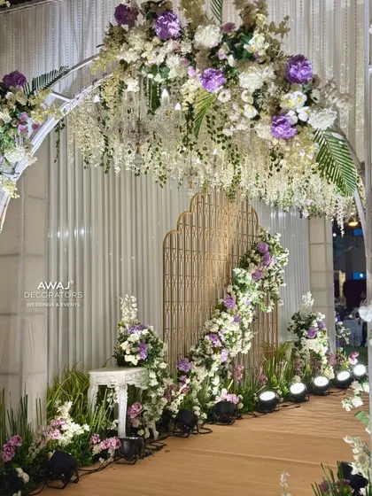 A peek through the floral archway, revealing a beautifully decorated path with intricate golden screens.