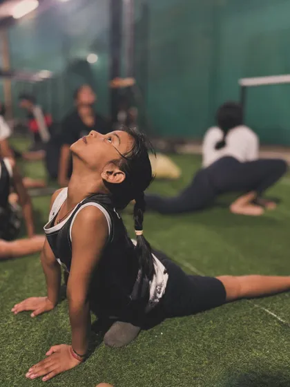 A young athlete working on her pigeon pose, a fantastic stretch for opening up the hips.