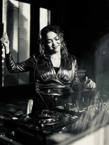 A classic black and white shot of me smiling at the decks, lost in the music.