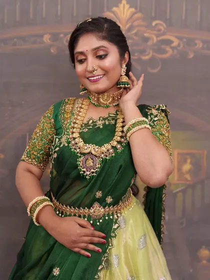 Another beautiful shot of this green half-saree look. The makeup enhances her features and brings a vibrant energy, perfect for a memorable celebration.