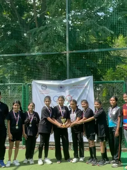 The winning girls' team from the Olympic Day Event proudly holds their trophy. Their success is a great motivator for all our female athletes.
