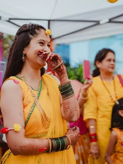 A candid shot of the bride, laughing and enjoying the moment, surrounded by family taking pictures.