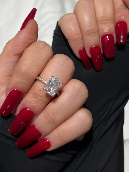 A close-up of the classic red coffin nails, highlighting the rich color and impeccable glossy finish.