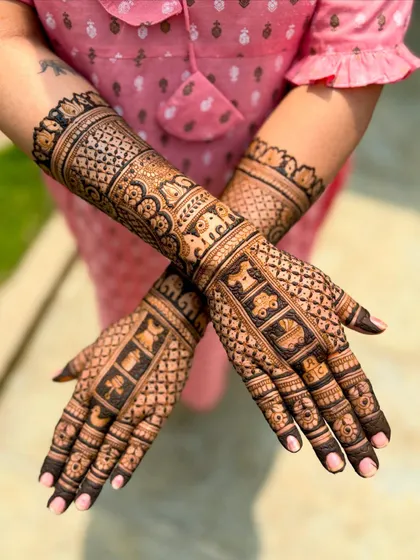 A crossed-hands view of the matching mother-daughter baby shower mehendi, emphasizing the coordinated patterns.