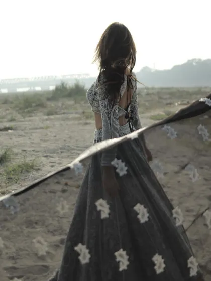 A dreamy shot of the black and white lehenga, with the embroidered dupatta flowing in the wind.