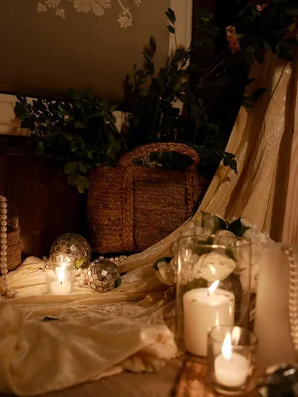 A detail shot of the floor decor, featuring candles, mini disco balls, and a rustic woven basket. These elements add texture and warmth to the space.