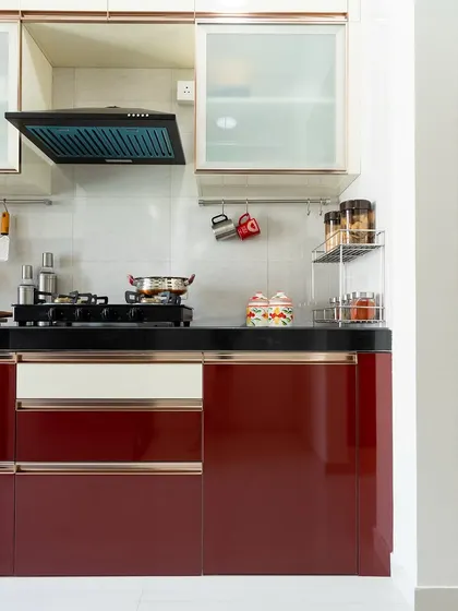 Another view of the red and white parallel kitchen, highlighting the chimney and overhead cabinets with frosted glass.