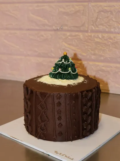 A rich chocolate version of our Christmas sweater cake. The detailed piping mimics a cozy knit pattern, topped with a festive tree.