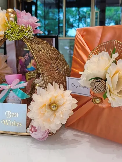 Another angle of the beautiful wedding hamper, showcasing the peach satin Furoshiki wrap and the floral arrangement on the golden basket.