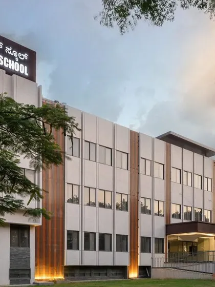 An angled view of the Jindal Public School, showing the rhythmic pattern of the facade panels and windows. The design provides a sophisticated and empowering environment for learning, reflecting our commitment to architecture for social change.
