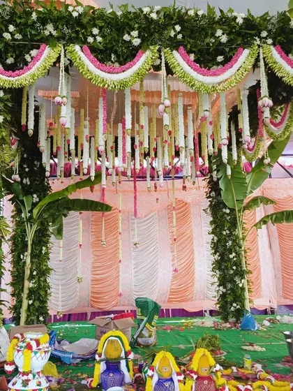 A close-up of a traditional mandap, showing the intricate floral work and items for the puja.