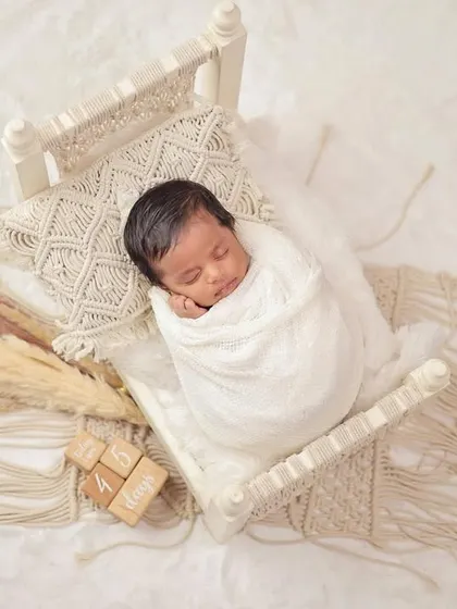 The peaceful, sleepy moments of a newborn are so fleeting. I specialize in creating serene and safe setups, like this cozy macrame bed, to capture your baby's earliest days in a simple, beautiful way.