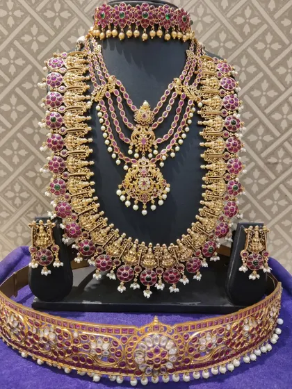 A full view of the multi-layered Kempu bridal set, a very grand and traditional choice.