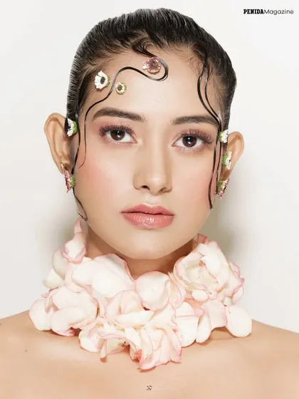 For this Penida Magazine editorial, I used fresh flower petals and delicate, gel-sculpted hair tendrils to create a look of soft, ethereal beauty. The makeup is clean and rosy to complement the floral theme.