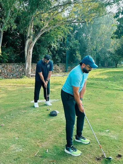 Two friends enjoying a practice session on the chipping green. Golf is better when it's shared.