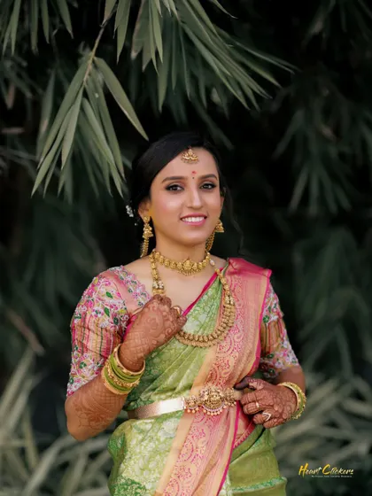A smiling bride in a beautiful pastel green and pink saree. This outdoor portrait captures her joy and elegance.