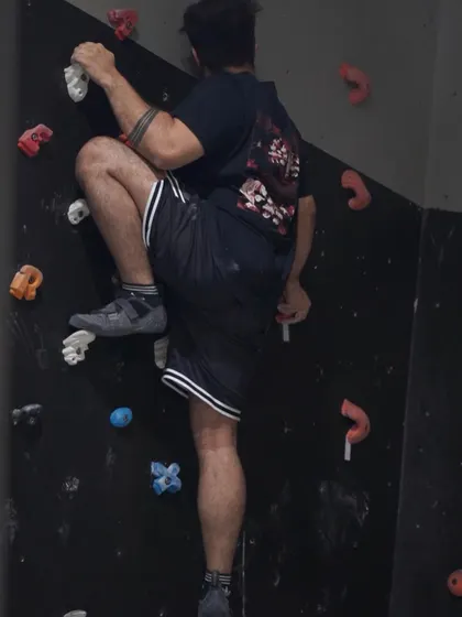 No mountains nearby? No problem! Indoor climbing offers all the thrills and challenges right here in the city. This climber is focused on a technical move, showcasing the strength and precision the sport builds.