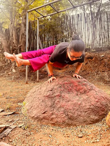 Balancing on a rock in Parsva Bakasana. This pose requires a combination of core strength, wrist strength, and mobility, connecting me to both my body and the earth.