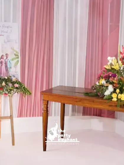 The welcome area for the reception featured the custom illustrated sign on an easel, along with a table adorned with a large, vibrant floral arrangement.