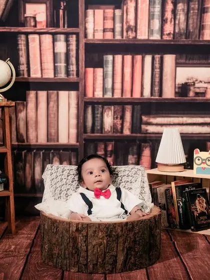 A curious little explorer in his library. He looks so handsome in his bowtie, ready to discover the world through books and maps.