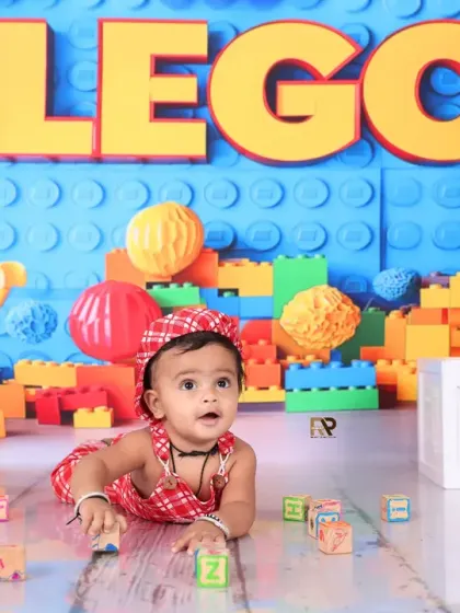 Another shot from the Lego theme, showing the baby crawling among the blocks. The giant Lego figure in the background adds to the playful and creative atmosphere.