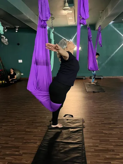 Age is no barrier in our studio. This member gracefully opens her chest in a supported backbend, showing how aerial yoga can be adapted for anyone looking to improve their mobility and strength.