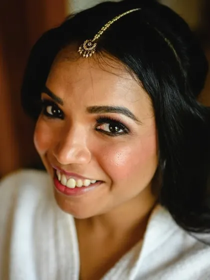 A close up of Amrutha during her makeup session. Her happy smile shows the excitement and anticipation of the wedding day.
