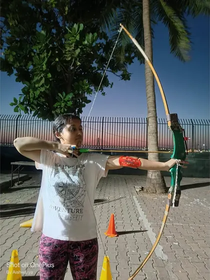 A student practices her shot, with the beautiful Mumbai sunset in the background.
