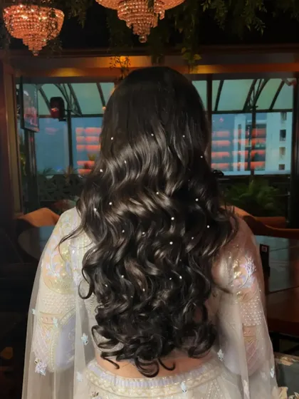 The hairstyle for this reception look featured soft waves adorned with delicate pearls, adding a touch of elegance and romance.