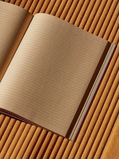 The ribbed texture of the 'Colonne' wallcovering provides a unique backdrop for a lined notebook, creating a visual parallel between the lines on the page and the lines on the wall.