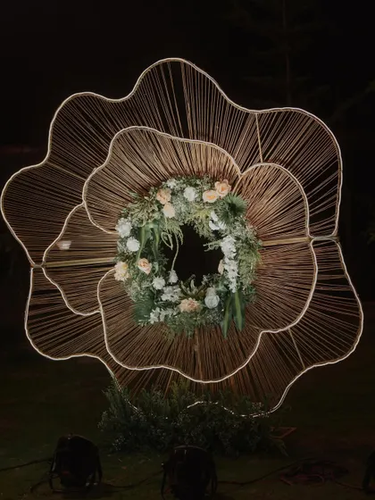 An artistic, large-scale floral light installation. This unique piece serves as a stunning photo-op and a beautiful decor element for an outdoor Sangeet.