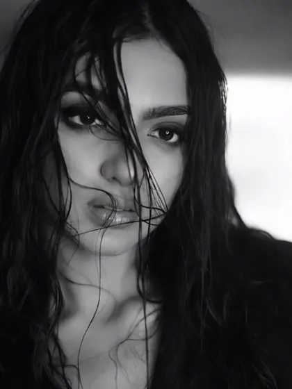 This close-up in monochrome emphasizes the raw emotion and the artistry of the makeup. The smudged liner and dewy skin texture are central to this moody, atmospheric shot.