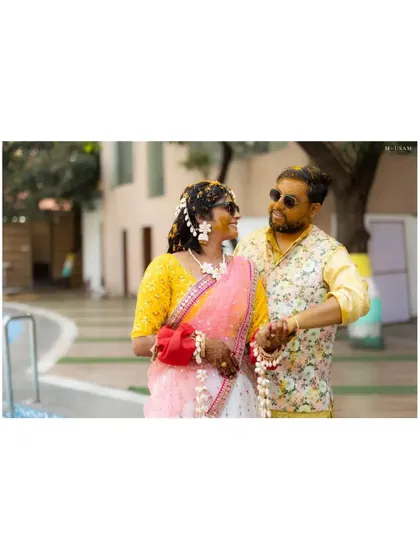 A happy couple, faces glowing with turmeric, walk hand-in-hand during their Haldi ceremony. This candid shot captures their easy chemistry and the relaxed, joyful vibe of the day.