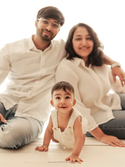 A joyful family portrait with a crawling baby front and center. A perfect lifestyle shot capturing a happy family moment.