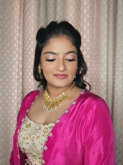A close-up of Neha's makeup, featuring shimmery pink eyeshadow and a flawless base.