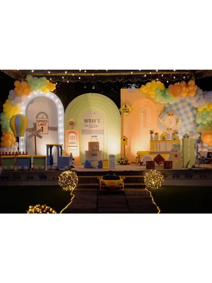 For the little one who loves all things that go, this transportation theme was a dream come true. This expansive stage setup features multiple illuminated arches, a mini-train, a ride-on car, and a hot air balloon, creating a bustling city of fun.