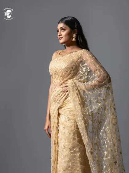 Simplicity is beautiful. This golden net saree with delicate embroidery is a perfect example of understated elegance, ideal for a reception or festive gathering.