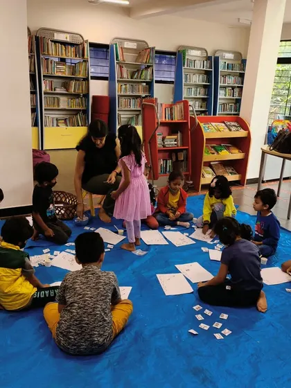 Working on a counting activity on the floor. These hands-on games help children visualize numbers and understand mathematical concepts in a tangible way.