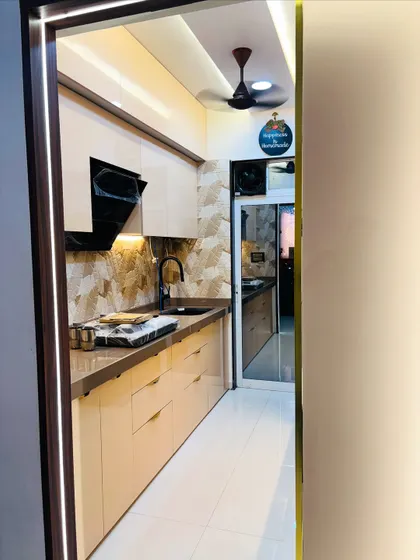 Another view of the beige kitchen, highlighting the seamless integration of the black sink and faucet with the countertop.