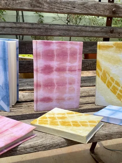 My collection of handmade notebooks, covered with fabric that I naturally dyed myself. They are available with ruled or unruled paper and are perfect for journaling, sketching, or gifting.