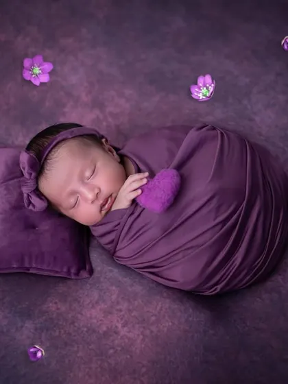 I'm in love with this beautiful purple setup. This sweet baby girl is swaddled comfortably, resting on a tiny matching pillow. Using a single colour scheme creates such a striking and artistic newborn photograph.