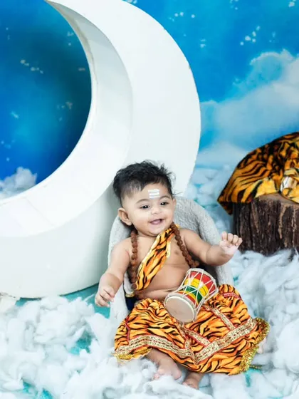 This older baby is a playful Lord Shiva, sitting on a crescent moon among the clouds of Kailash.