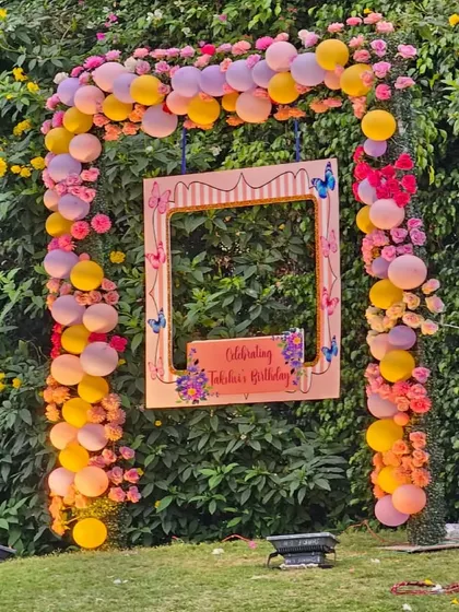 A custom photo booth frame is a great way to capture memories. For this birthday, we designed a personalized frame surrounded by a colorful balloon and flower arch against a natural green backdrop.